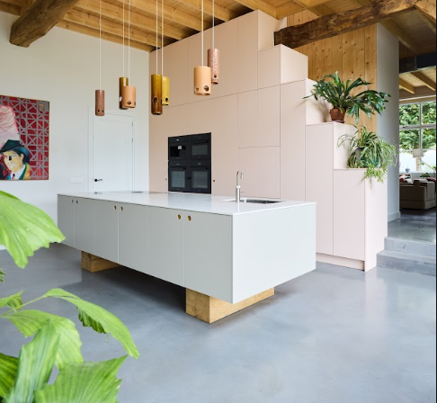 Wit kookeiland op houten blokken met zachtroze kastenwand